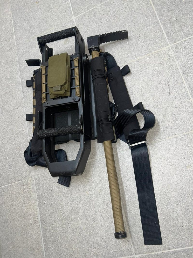 Taktisches Ramme- und Brecheisen-Set mit Transportträger für Spezialeinheiten, einsatzbereit auf grauem Boden